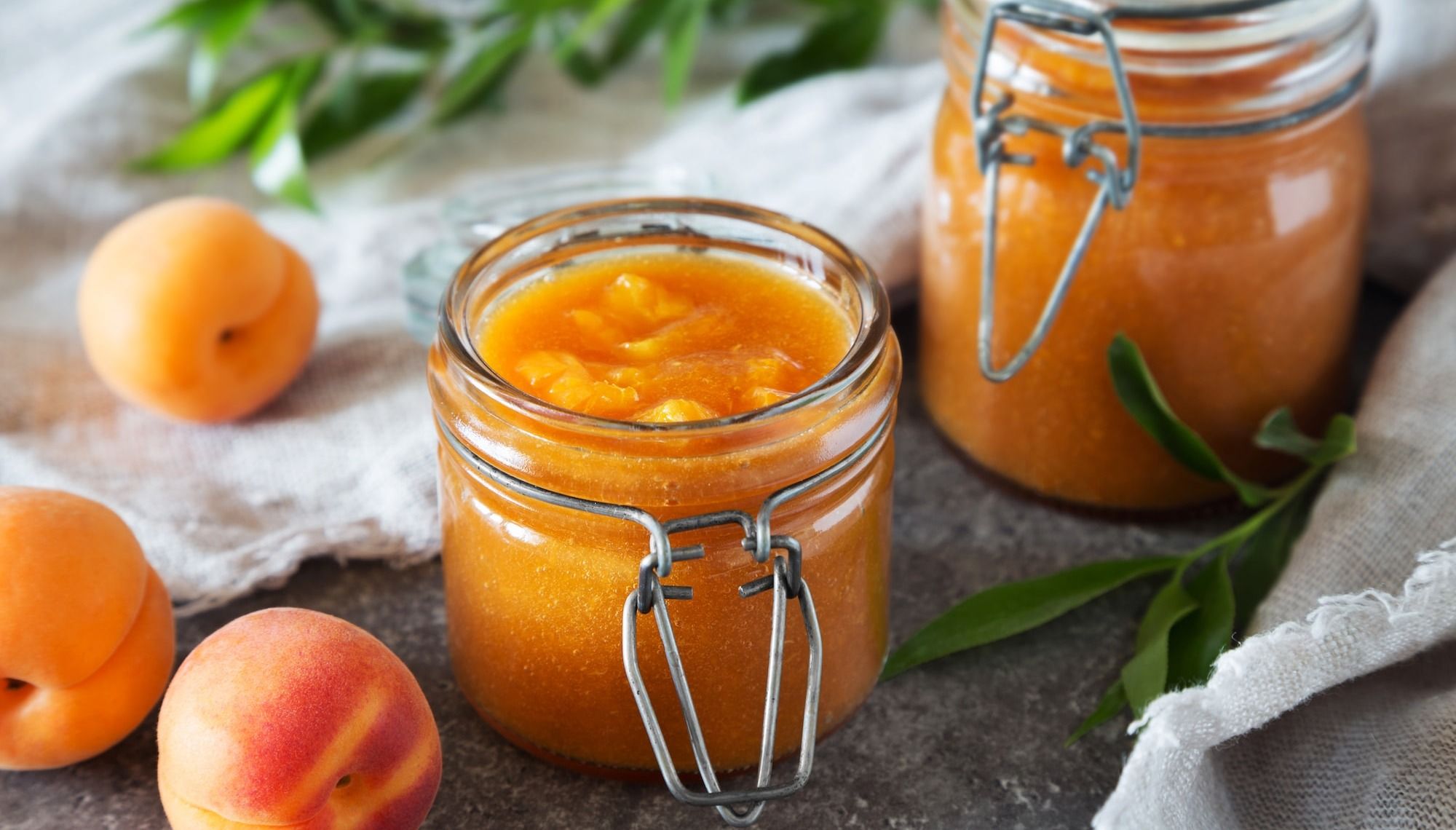 a jar of orange juice next to a jar of oranges